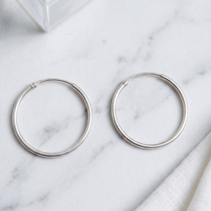 Silver hoop earrings on a marble surface