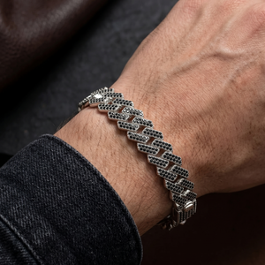 Silver bracelet on a wrist with a dark background