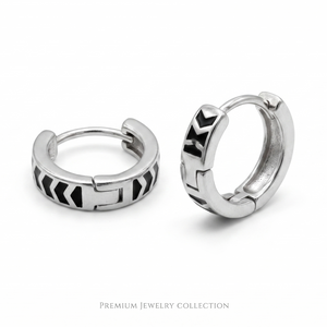 Pair of silver hoop earrings with geometric designs on a white background