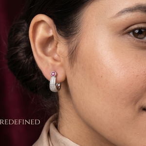 Close-up of a woman wearing earrings with a dark background