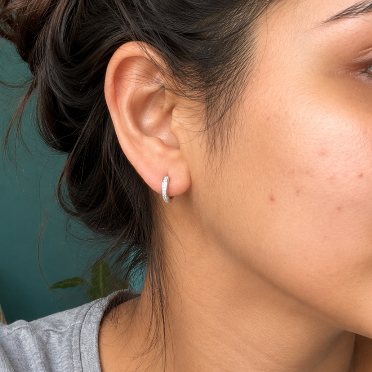 Close-up of a woman wearing a silver earring with a blurred background