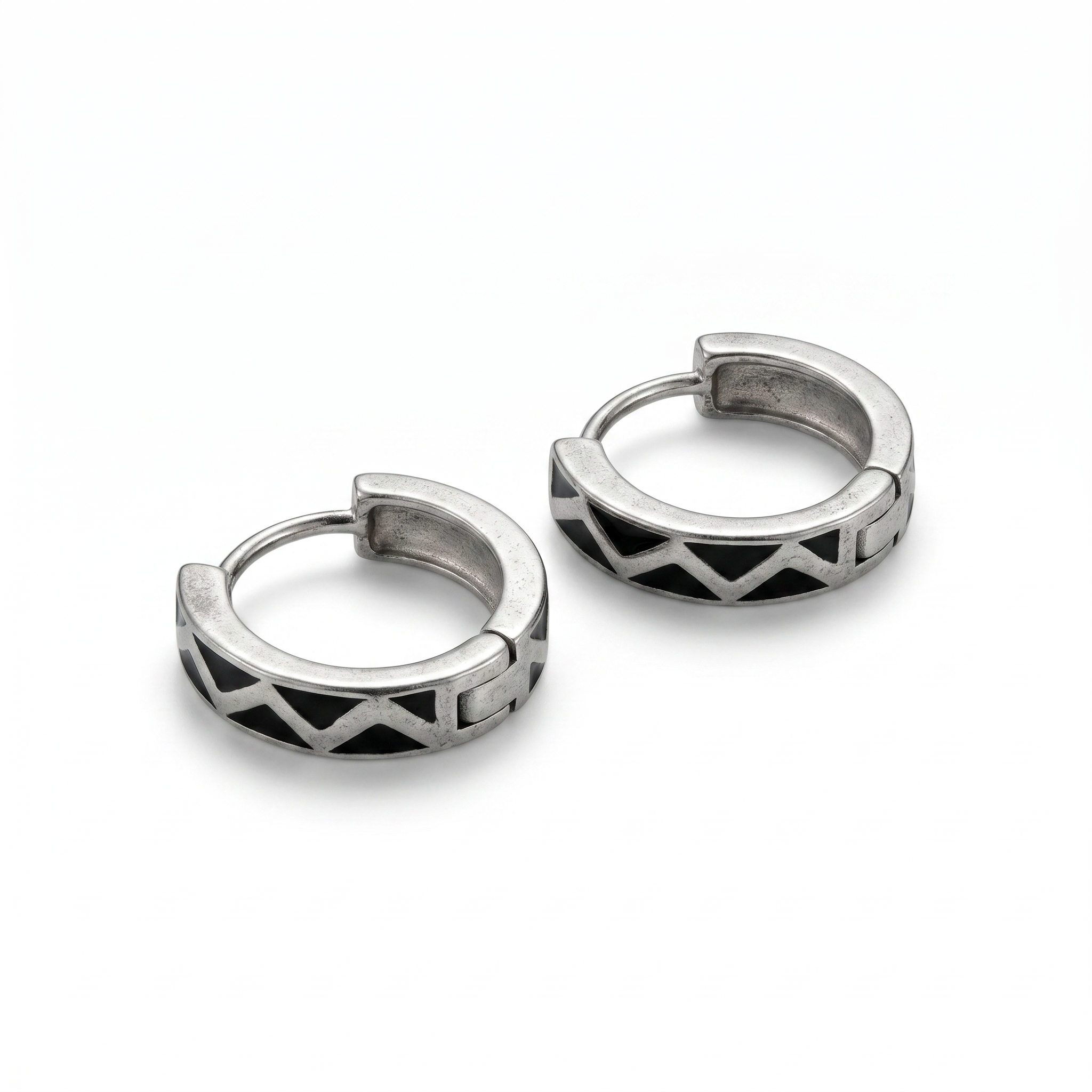 Pair of silver hoop earrings with geometric design on a white background