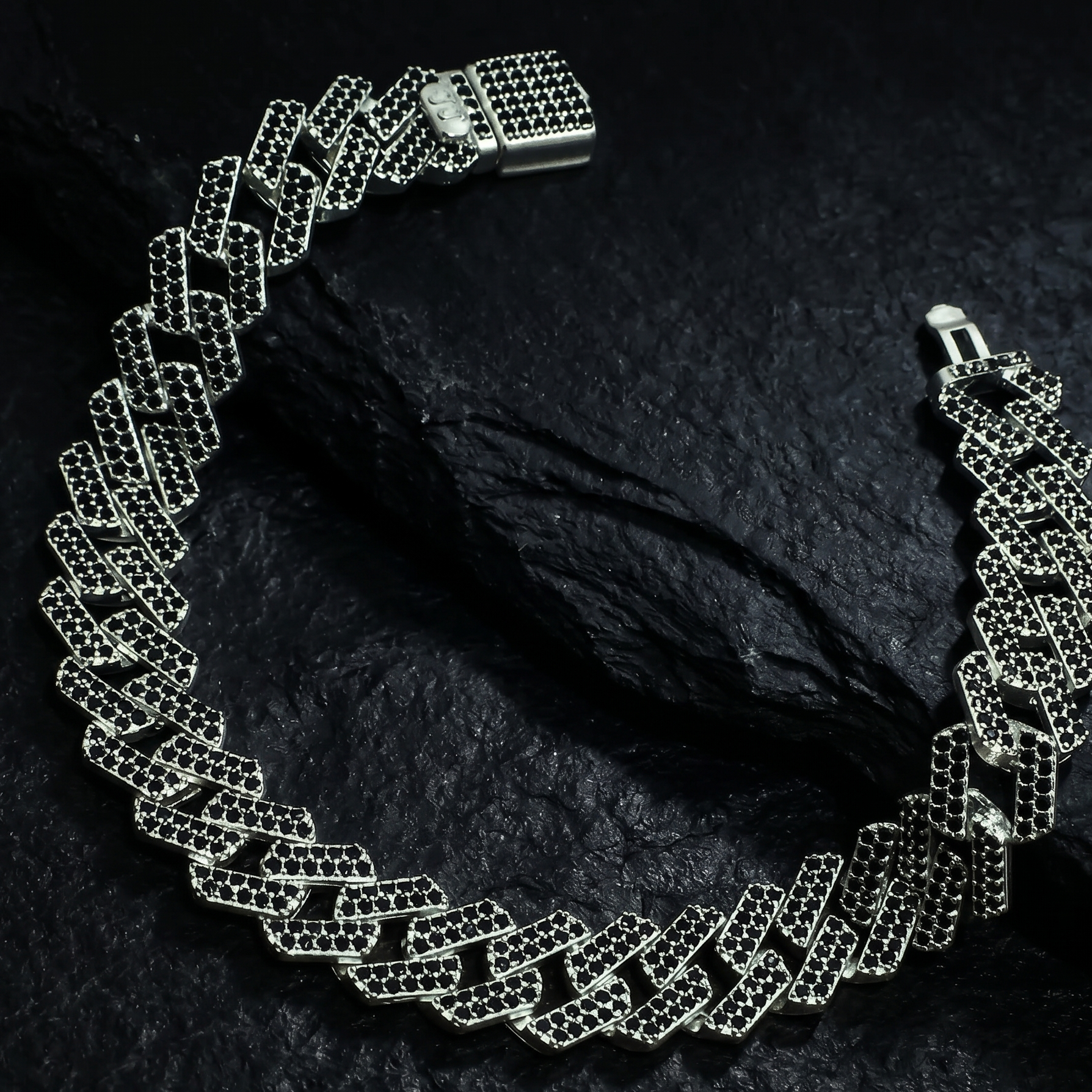 Silver chain necklace on a dark textured bracelet