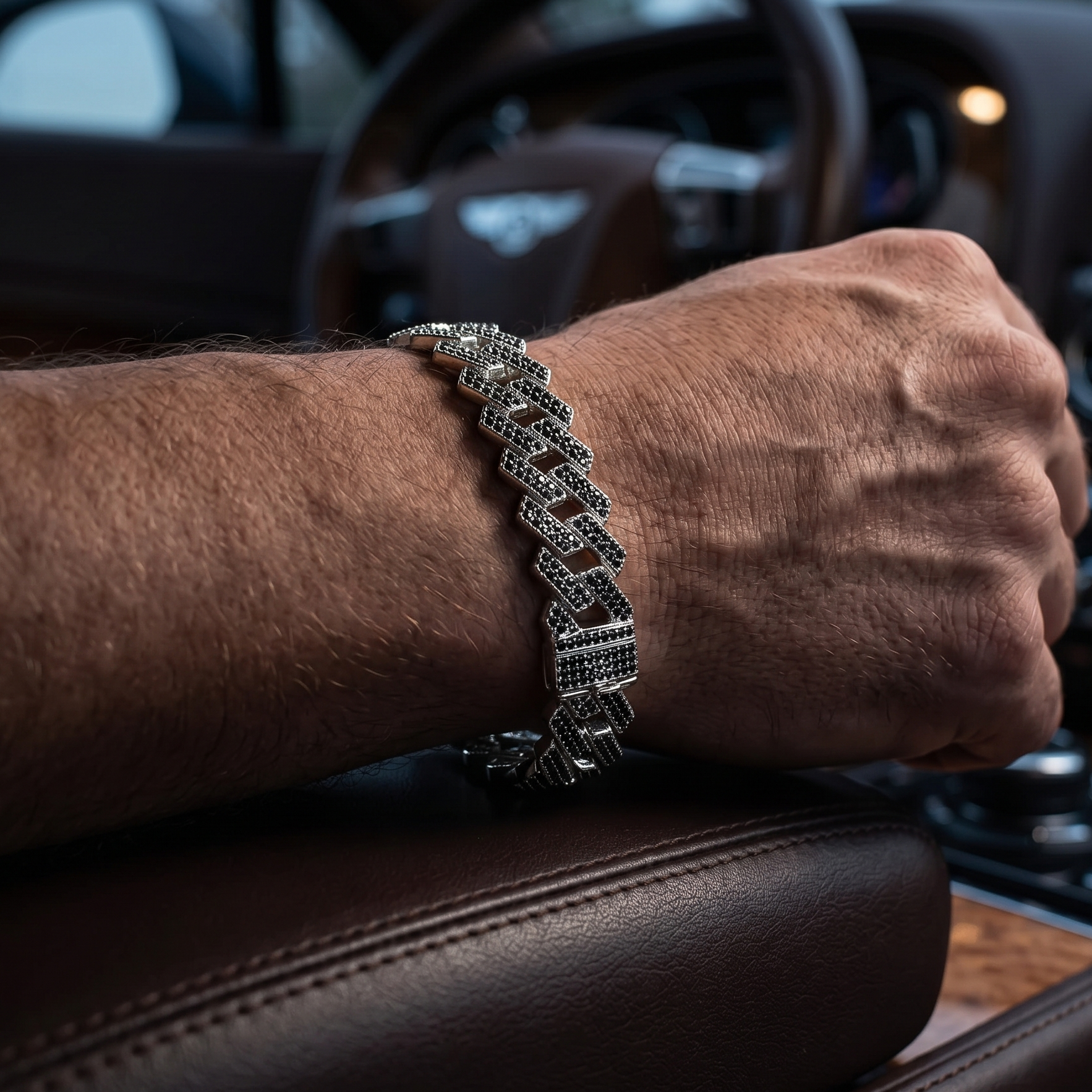 Person wearing a silver bracelet inside a car.