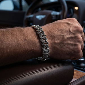 Person wearing a silver bracelet inside a car.
