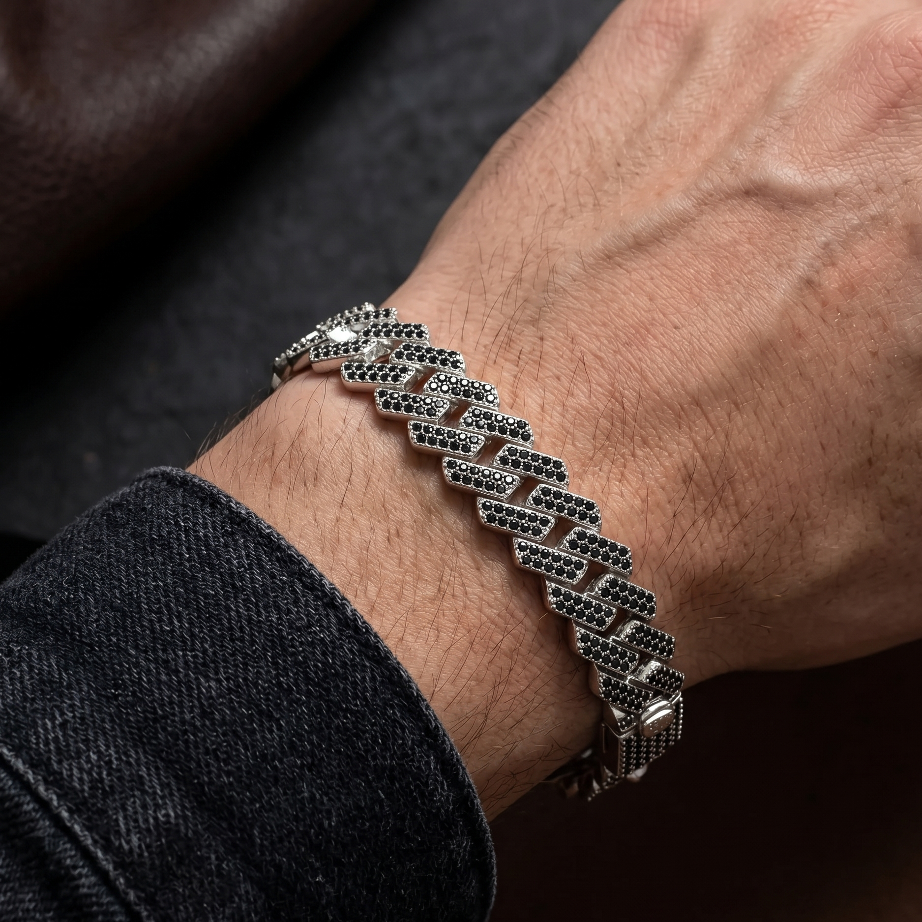 Silver bracelet on a wrist with a dark background
