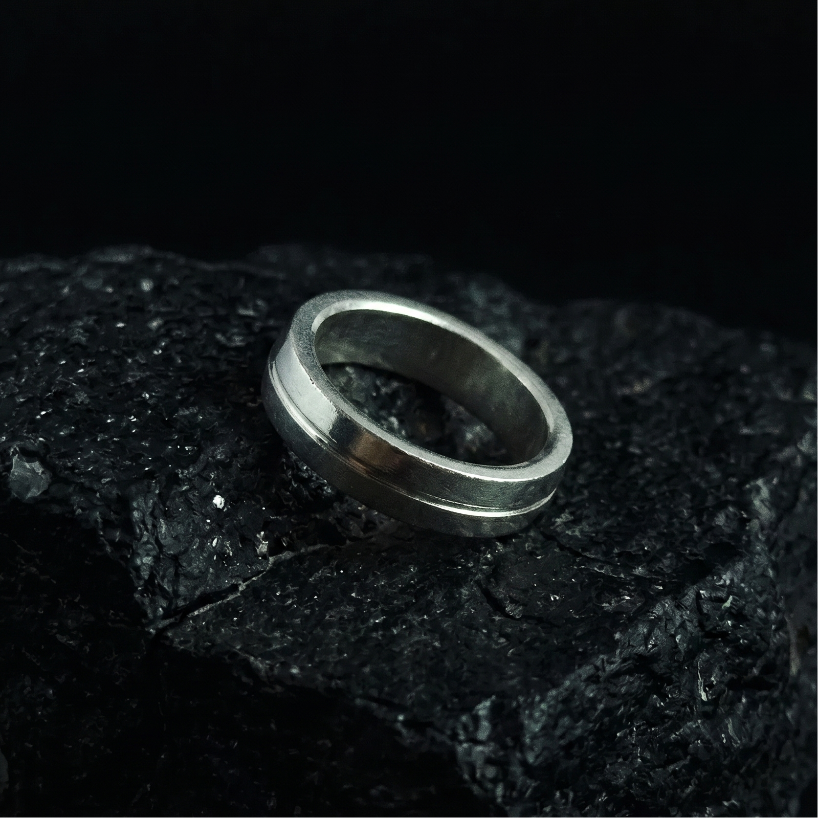Silver ring on a dark textured surface