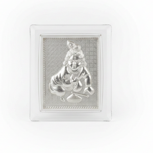 Silver idol in a crystal frame on a festive background with lights and flowers.