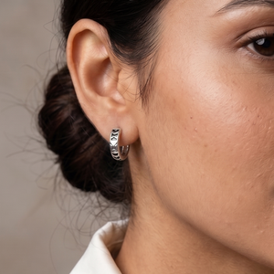 Woman wearing earrings with a neutral background